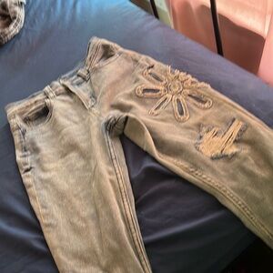 I’m selling these blue jeans with flowers on them it is a size 8